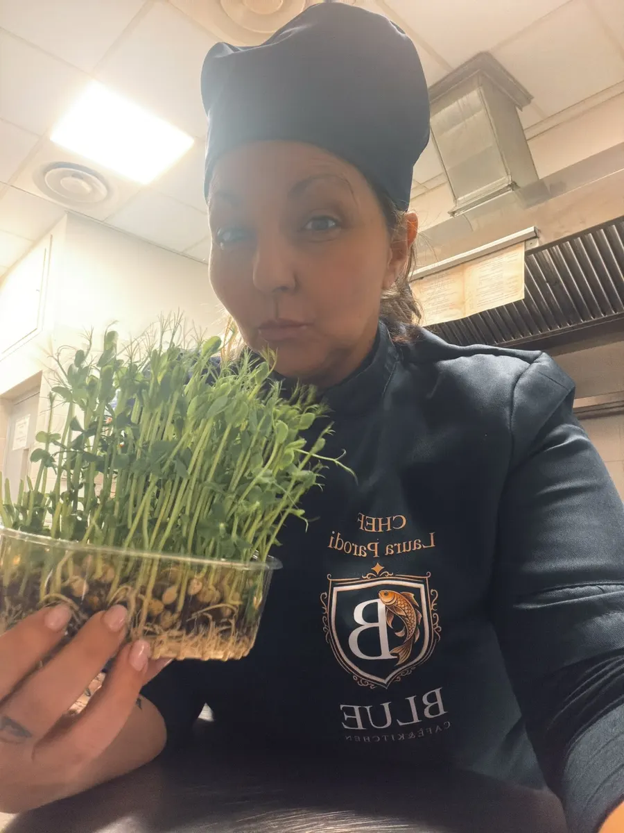Laura Parodi in cucina con una vaschetta di germogli freschi