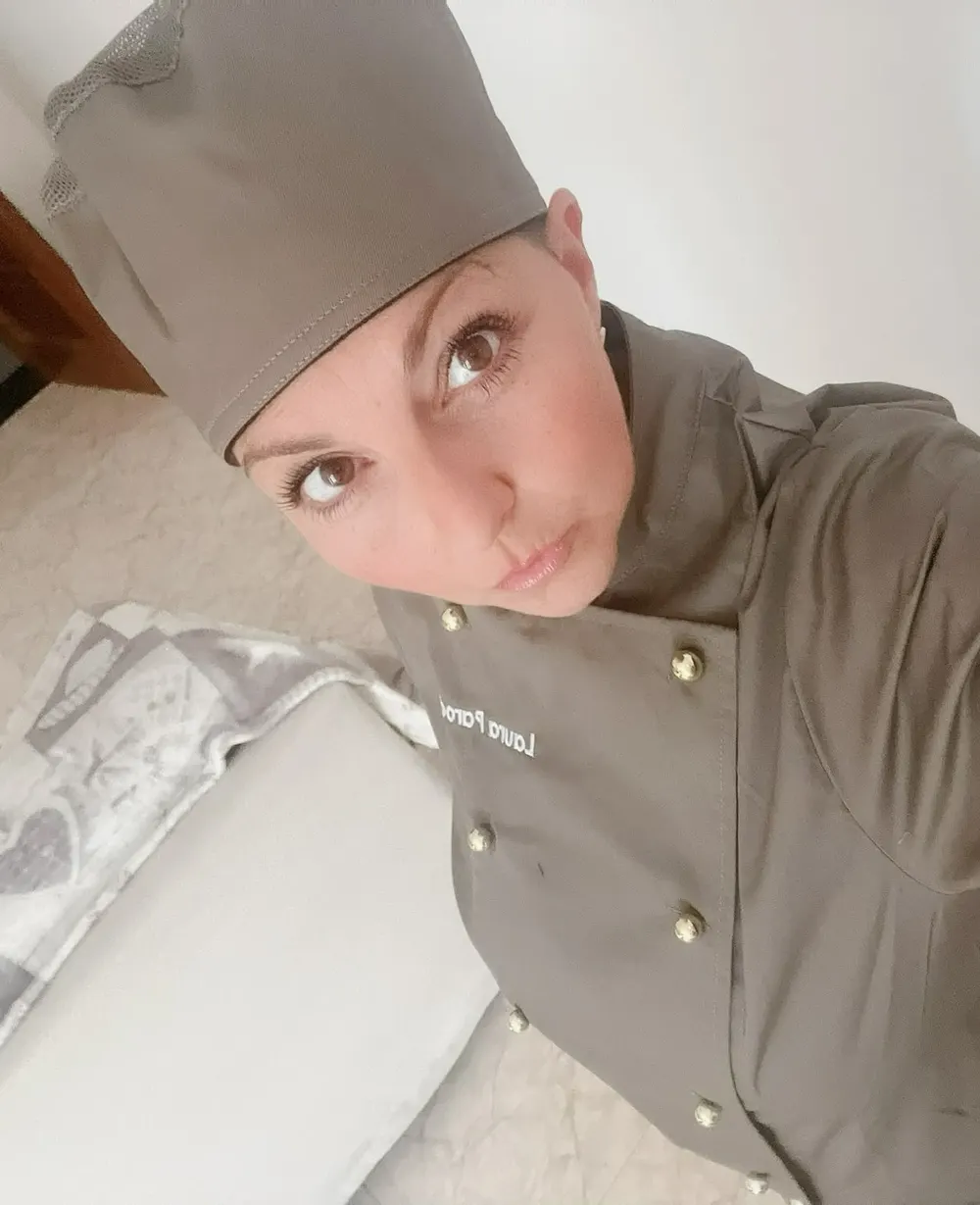 La chef Laura Parodi con la giacca da cuoca dai bottoni dorati